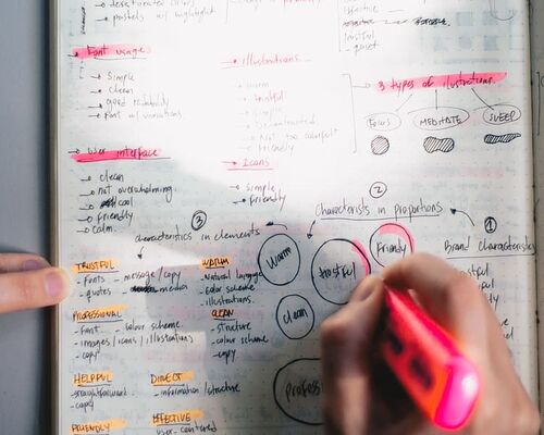 person-holding-pink-highlighter-pen